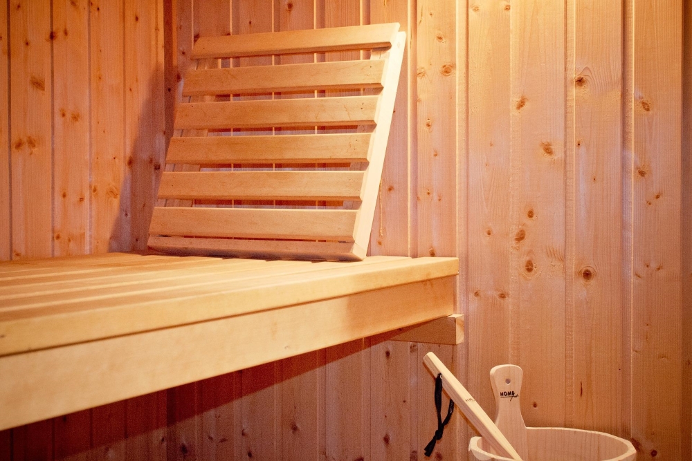 Obrázek zobrazuje: Ke kombinované sauně můžete zvolit řadu doplňků, jako je opěrka pod hlavu a vědro na vodu s naběračkoU